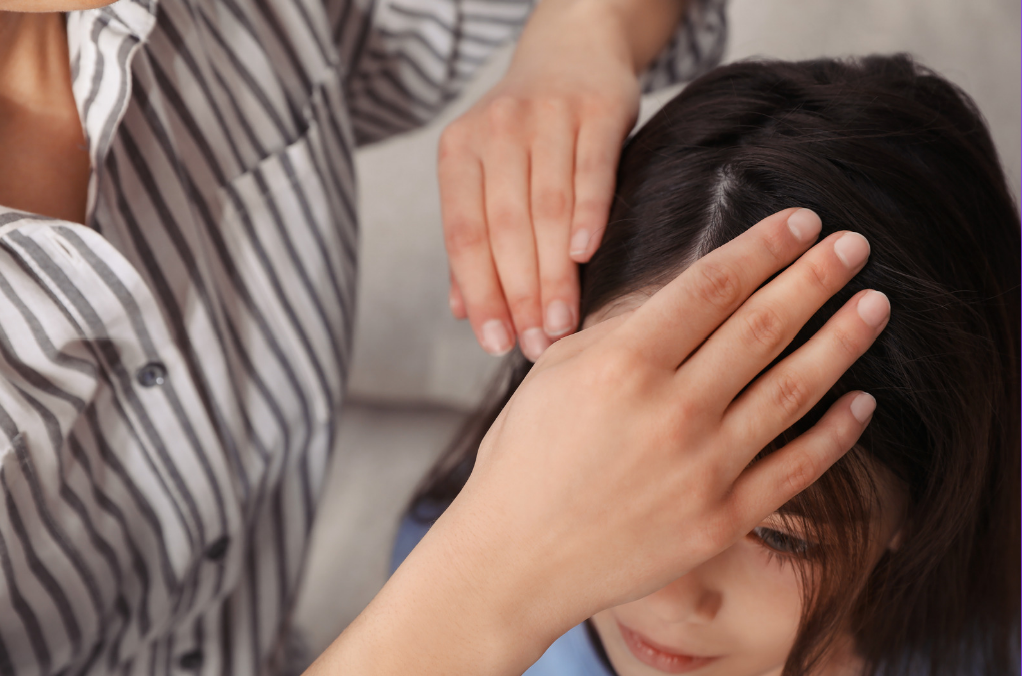 Professional lice examination showing gentle hands checking child's hair
